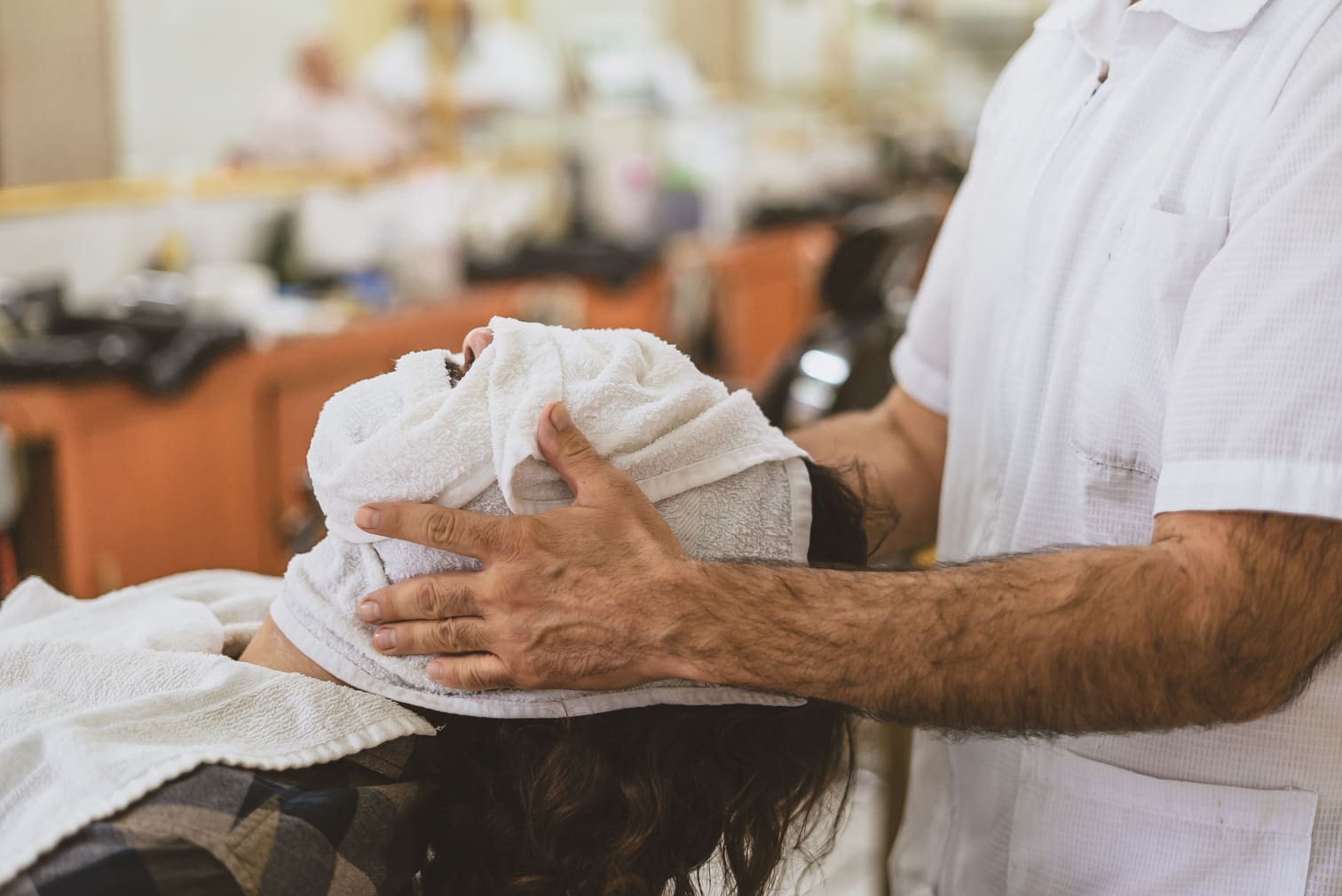 A stylist finishing a treatment with a regular customer